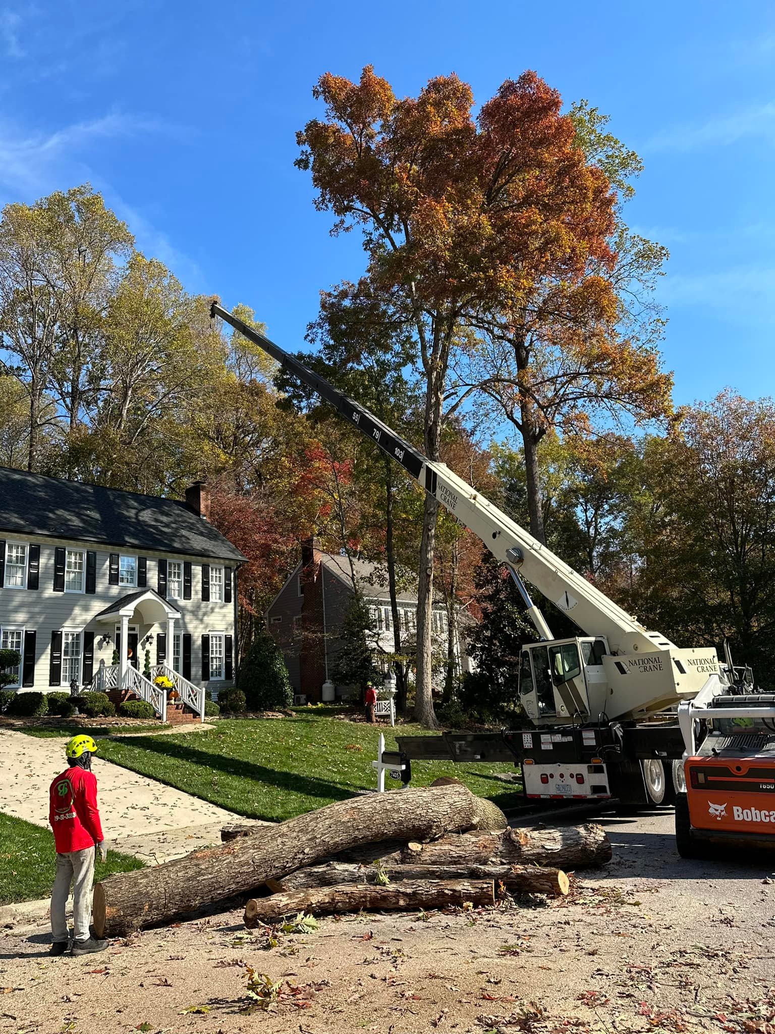 Crane-assisted removal beside a home